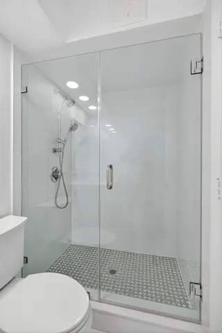 an empty room with wooden floor and fan