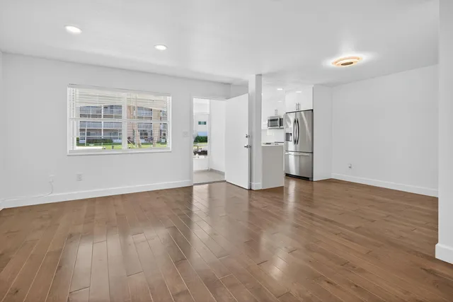a view of an empty room with closet and wooden floor