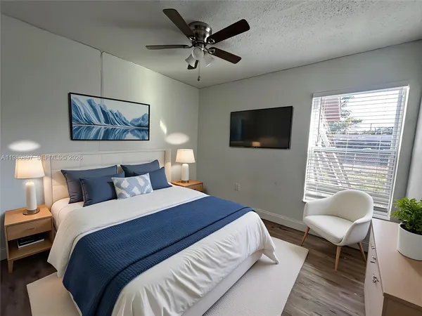 a bedroom with a bed a couch and a flat screen tv