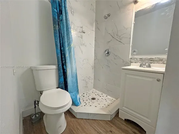 a bathroom with a sink a toilet and shower