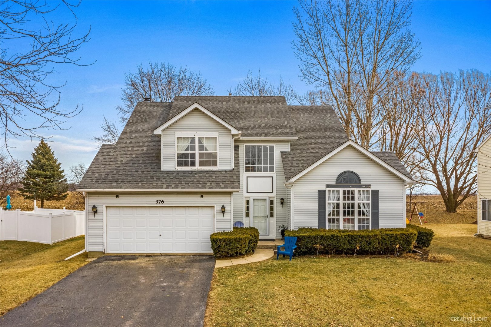 a view of a yard in front of a house with a large tree