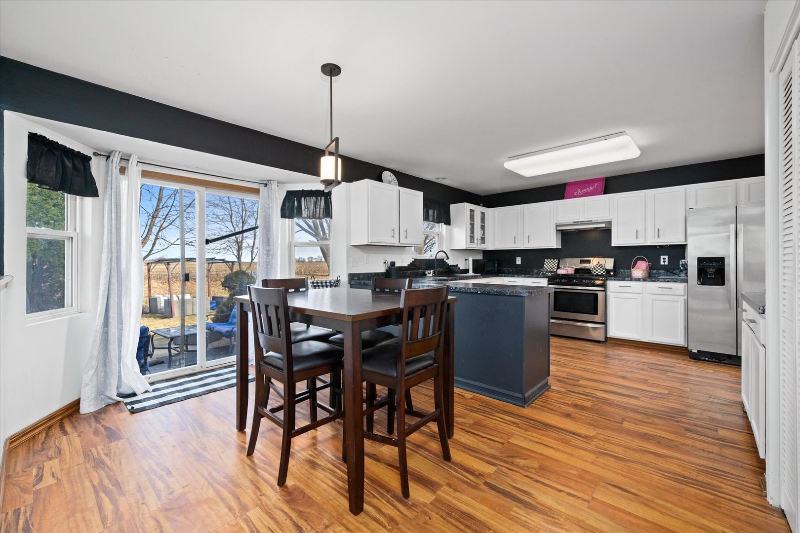 376 Brookhaven Circle Sugar Grove, IL 60554 - Photo 12 of 33 a kitchen with stainless steel appliances granite countertop a stove top oven a refrigerator a sink and a dining table with wooden floor