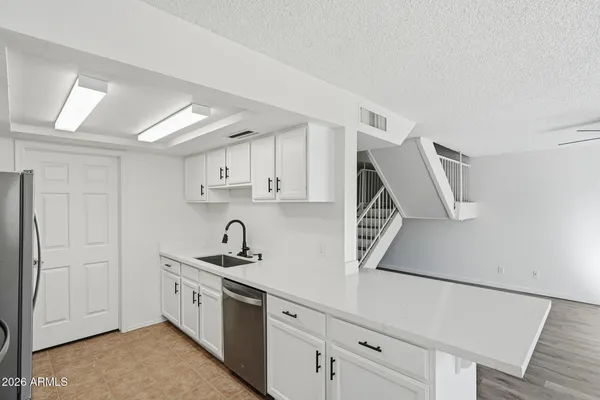 a kitchen with a sink a refrigerator and cabinets