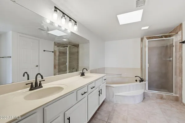 a bathroom with a tub a sink and mirror