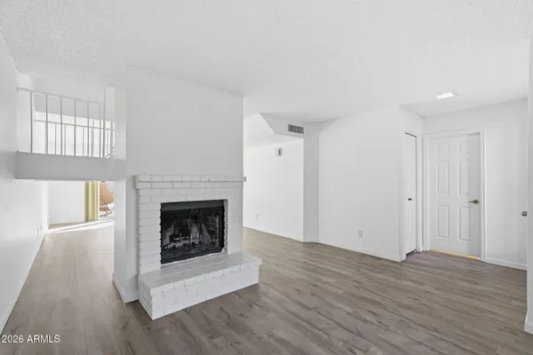 a living room with a fireplace and wooden floor