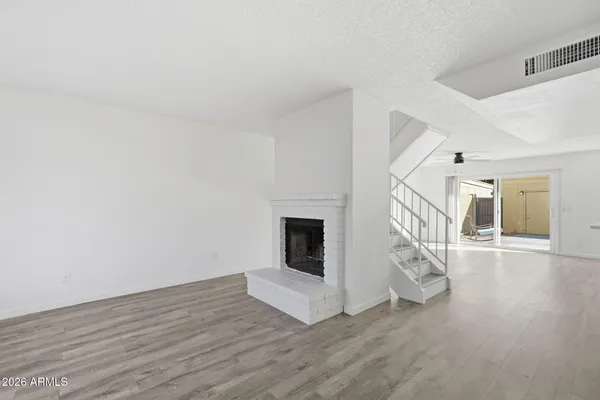 a view of a livingroom with wooden floor and a fireplace