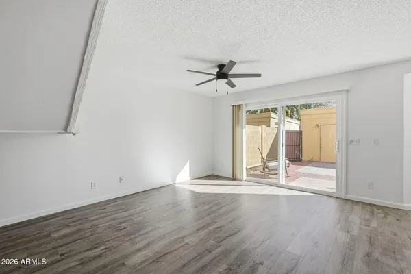 a view of a livingroom with wooden floor and a ceiling fan