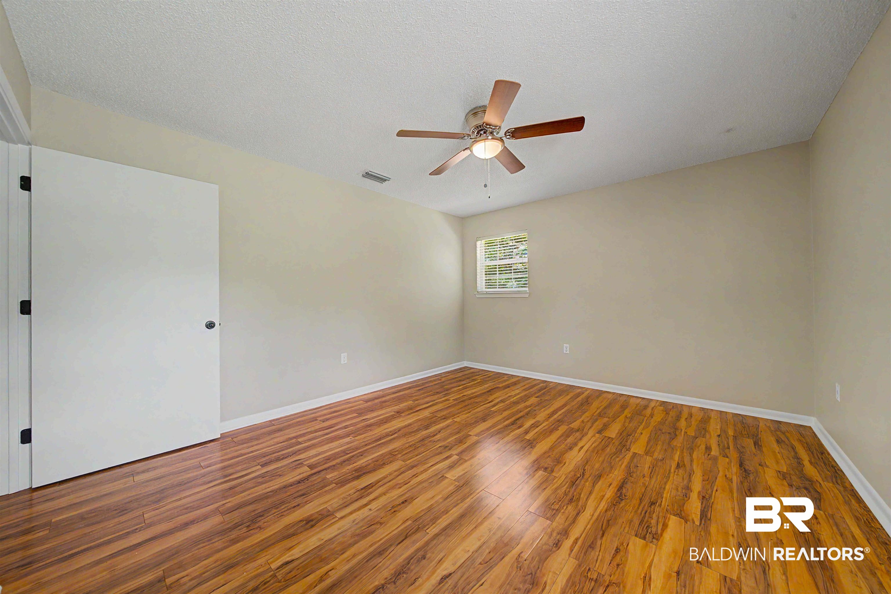 22963 Highway 98 Foley, AL 36535 - Photo 19 of 52 Light-filled room featuring wood-finish flooring, neutral wall tones, a ceiling fan with integrated lighting, and a single window
