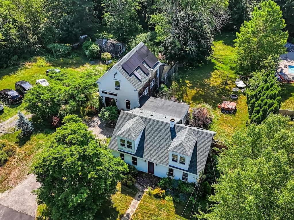 an aerial view of a house with garden space and a swimming pool