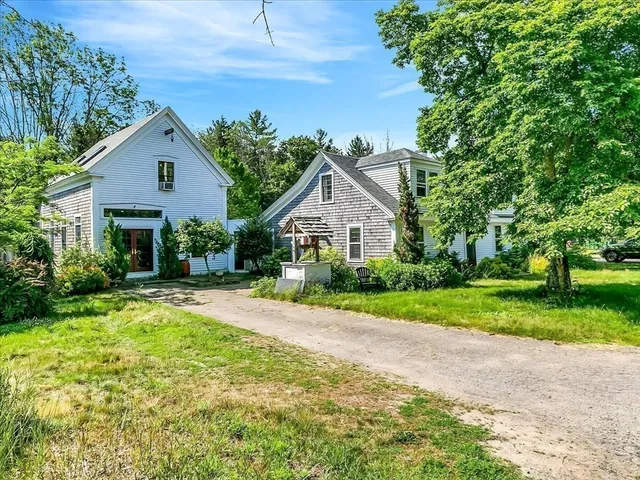 a front view of a house with yard and green space