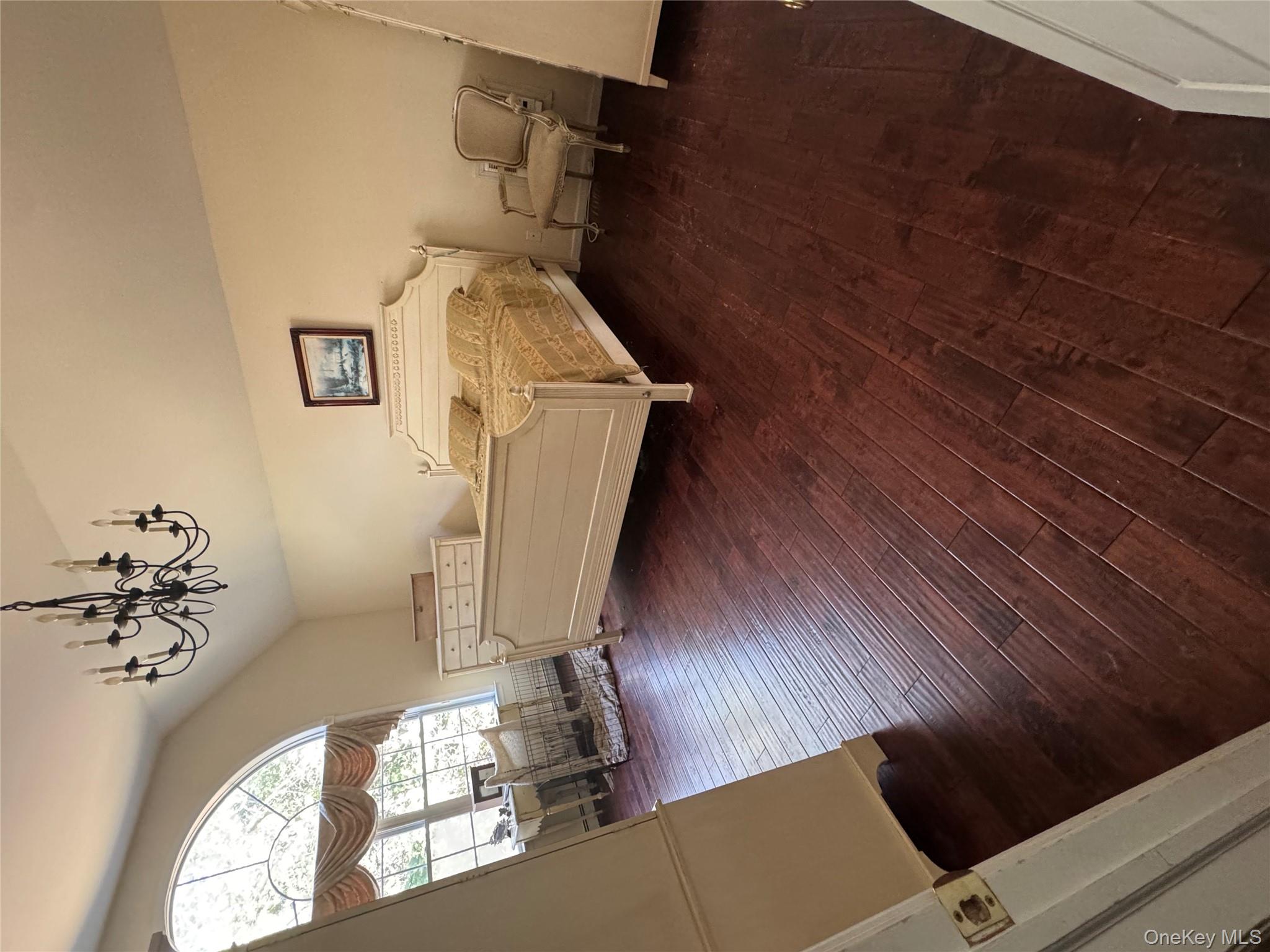 43 North Cozine Road Manorville, NY 11949 - Photo 19 of 42 Bedroom with lofted ceiling, dark wood-style flooring, and a chandelier