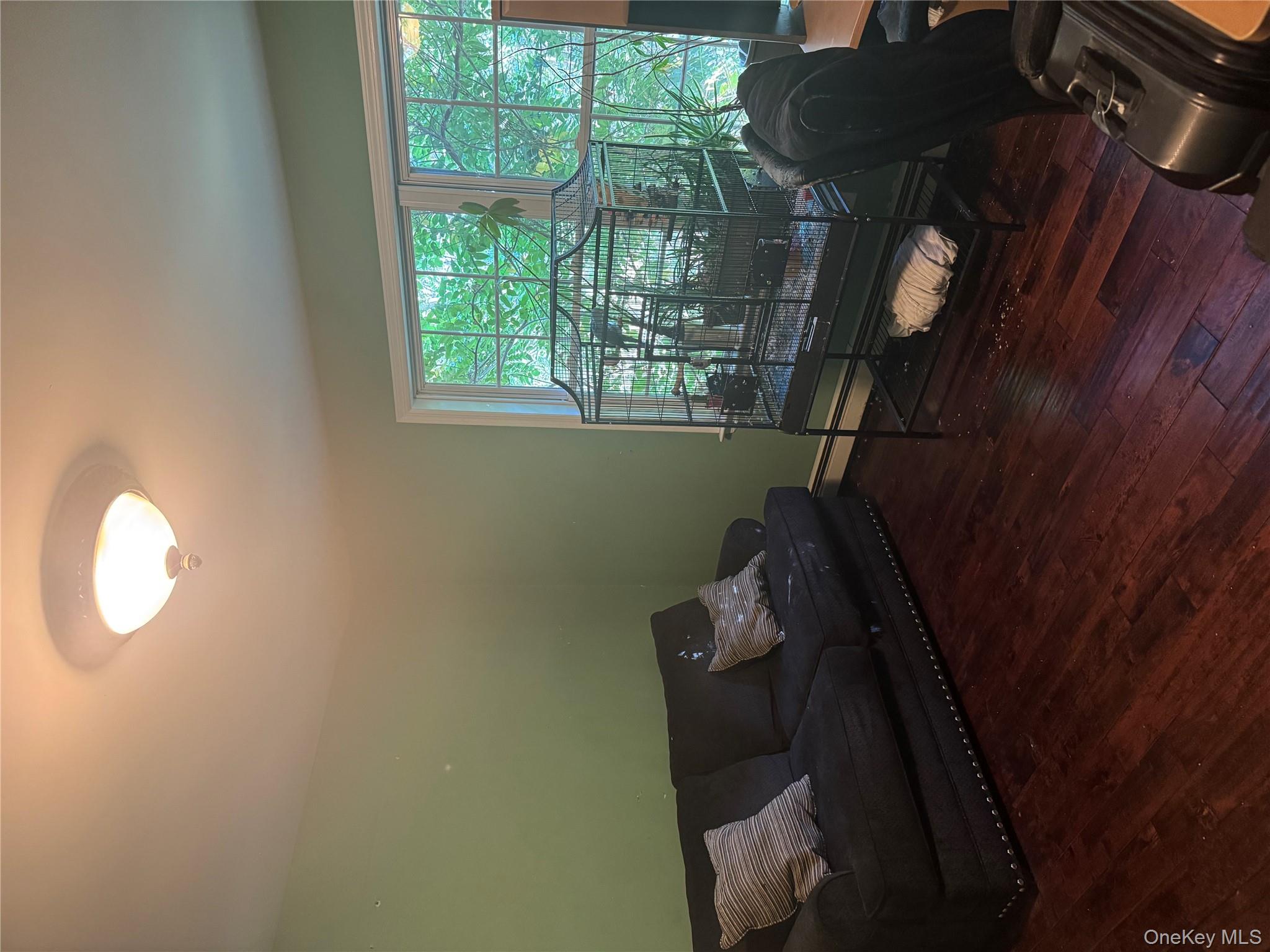 43 North Cozine Road Manorville, NY 11949 - Photo 27 of 42 Living area featuring dark wood finished floors and a baseboard heating unit