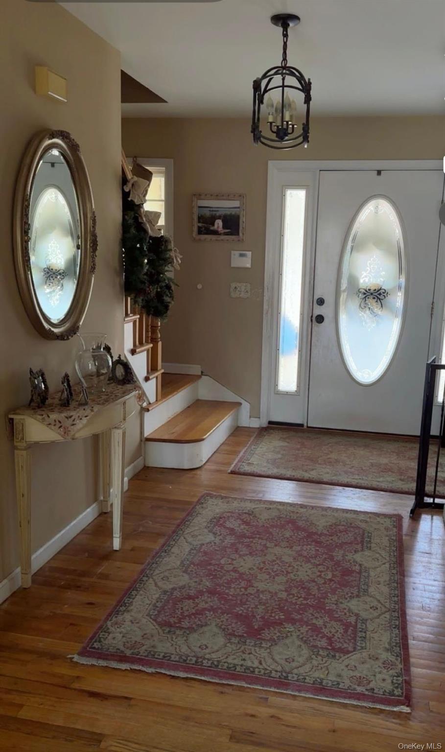43 North Cozine Road Manorville, NY 11949 - Photo 10 of 42 Entryway featuring plenty of natural light, a chandelier, and light wood-type flooring