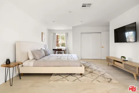 a bedroom with a bed and a large window