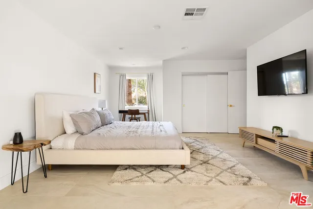 a bedroom with a bed and a large window