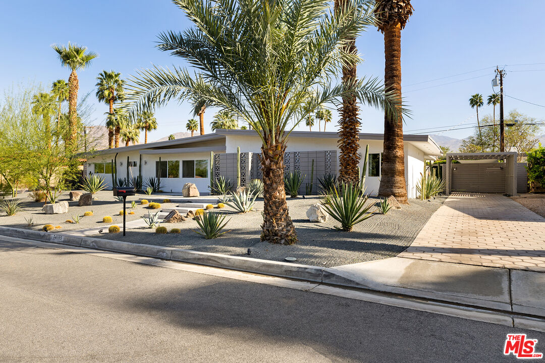 74085 Setting Sun Trail Palm Desert, CA 92260 - Photo 10 of 52 a view of a brick house with large windows and palm trees