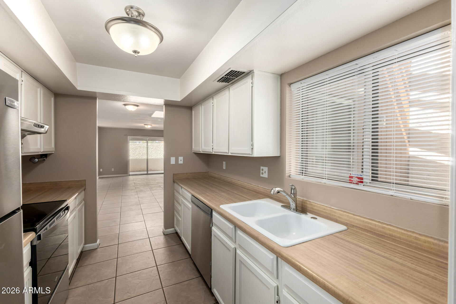 4529 West McLellan Road Glendale, AZ 85301 - Photo 13 of 35 a kitchen with a sink a stove cabinets and a wooden floor