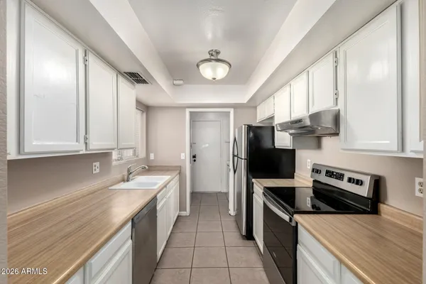 a kitchen with stainless steel appliances a stove sink microwave and cabinets
