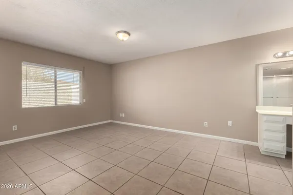 a view of an empty room with window and cabinet