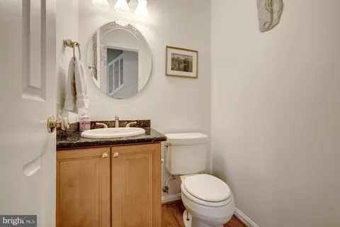 a bathroom with a granite countertop toilet sink and mirror