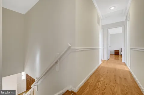 a view of a hallway with wooden floor and staircase