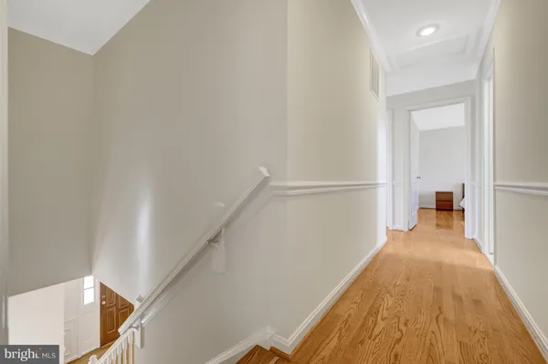 a view of a hallway with wooden floor and staircase