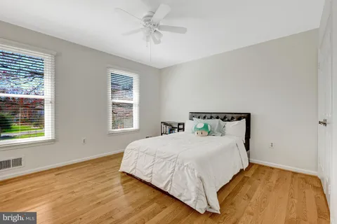 a bedroom with a bed and wooden floor