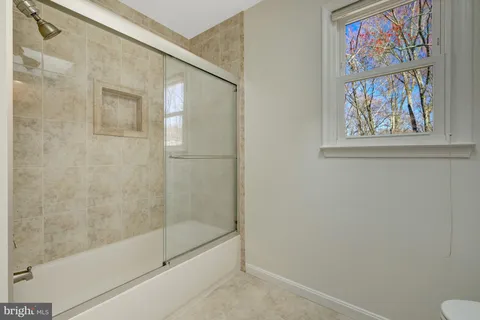 a bathroom with a painting on the wall and a shower