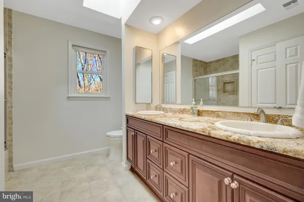 a bathroom with a granite countertop double vanity and a mirror