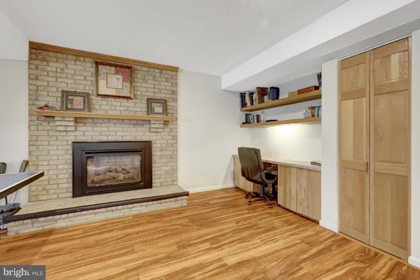 a view of a livingroom with a fireplace and workspace