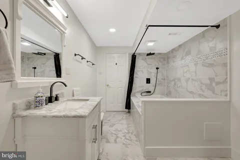 a bathroom with a granite countertop sink a toilet and a mirror