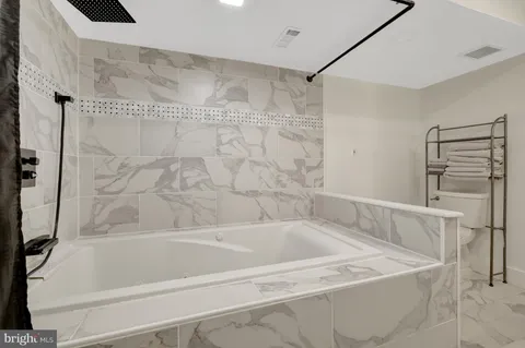 a bath tub sitting next to a white sink and vanity