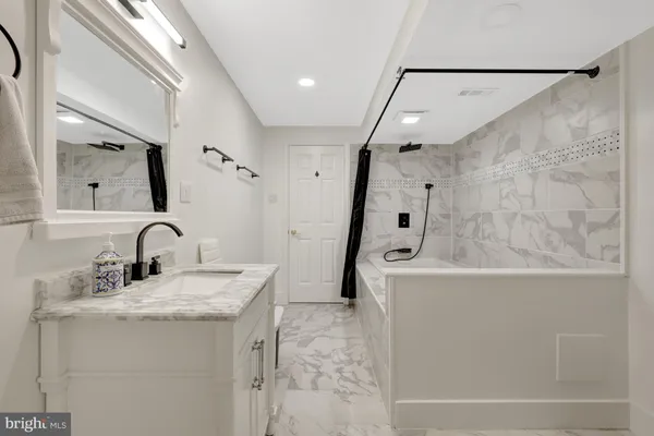 a bathroom with a granite countertop sink a toilet and a mirror