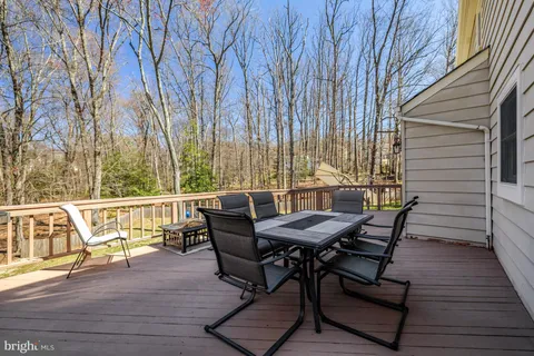 a view of a roof deck with table and chairs with wooden floor and fence