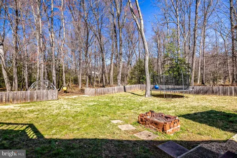 a view of swimming pool with lawn chairs and trees