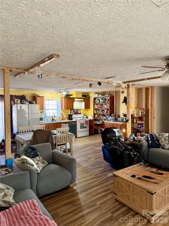 a living room with furniture and a view of kitchen