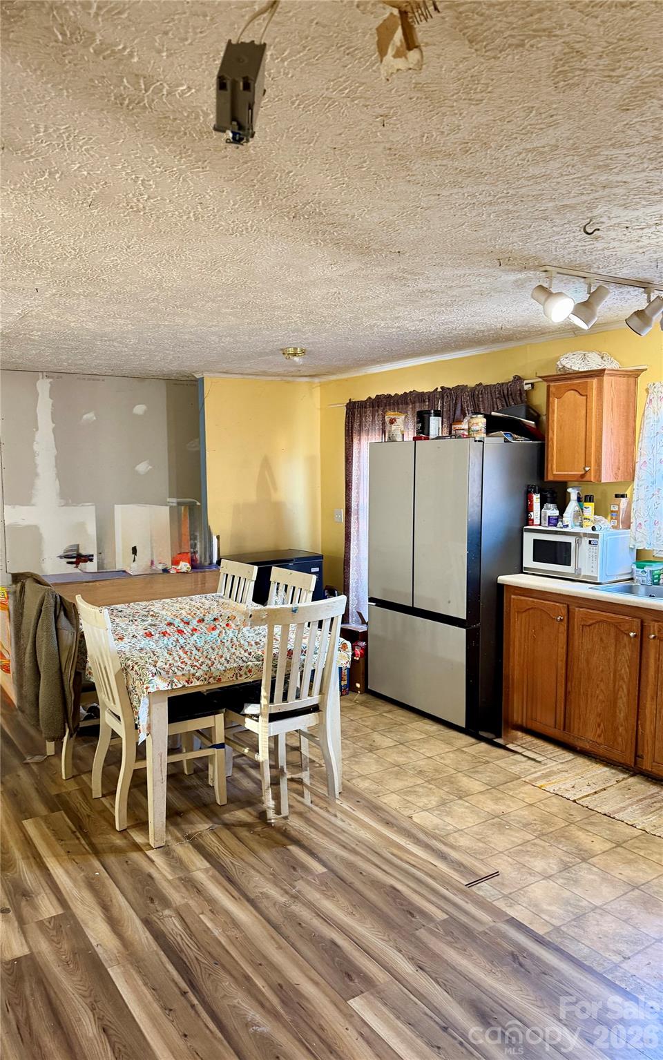 600 Scottdale Road Canton, NC 28716 - Photo 18 of 20 a kitchen with stainless steel appliances granite countertop a stove a refrigerator a sink a dining table and chairs with wooden floor