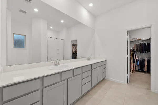 a spacious bathroom with a double vanity sink and a mirror