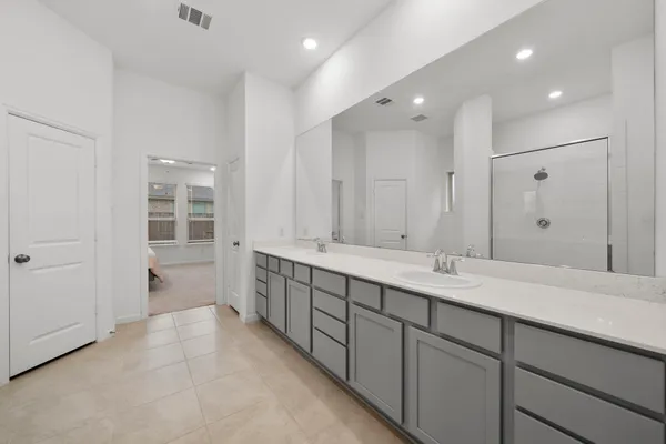 a spacious bathroom with a double vanity sink mirror and shower
