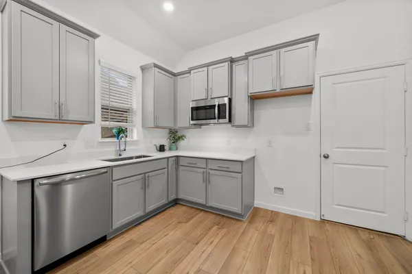 a kitchen with a sink cabinets and wooden floor