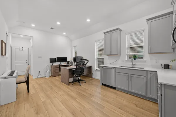 a large white kitchen with a window and wooden floor