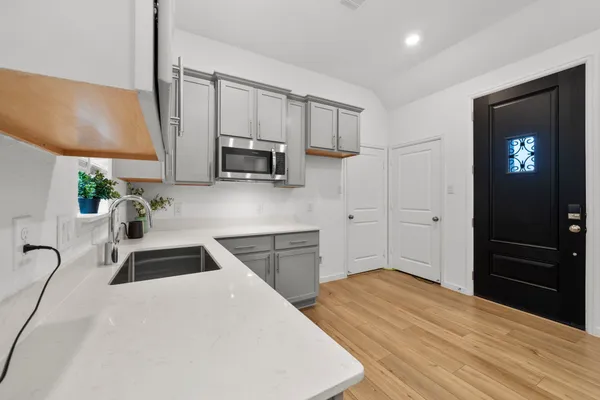 a kitchen with granite countertop a sink a stove and cabinets