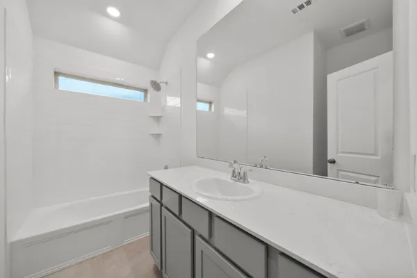 a bathroom with a sink double vanity granite tub shower and a mirror