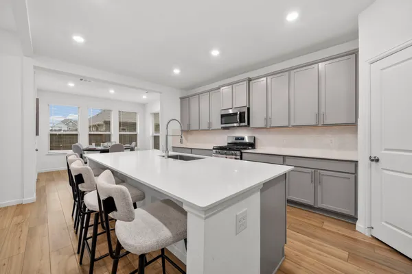 a kitchen with a table chairs refrigerator and cabinets