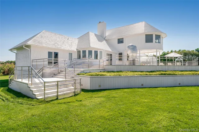 a view of a house with a large window and a yard with plants