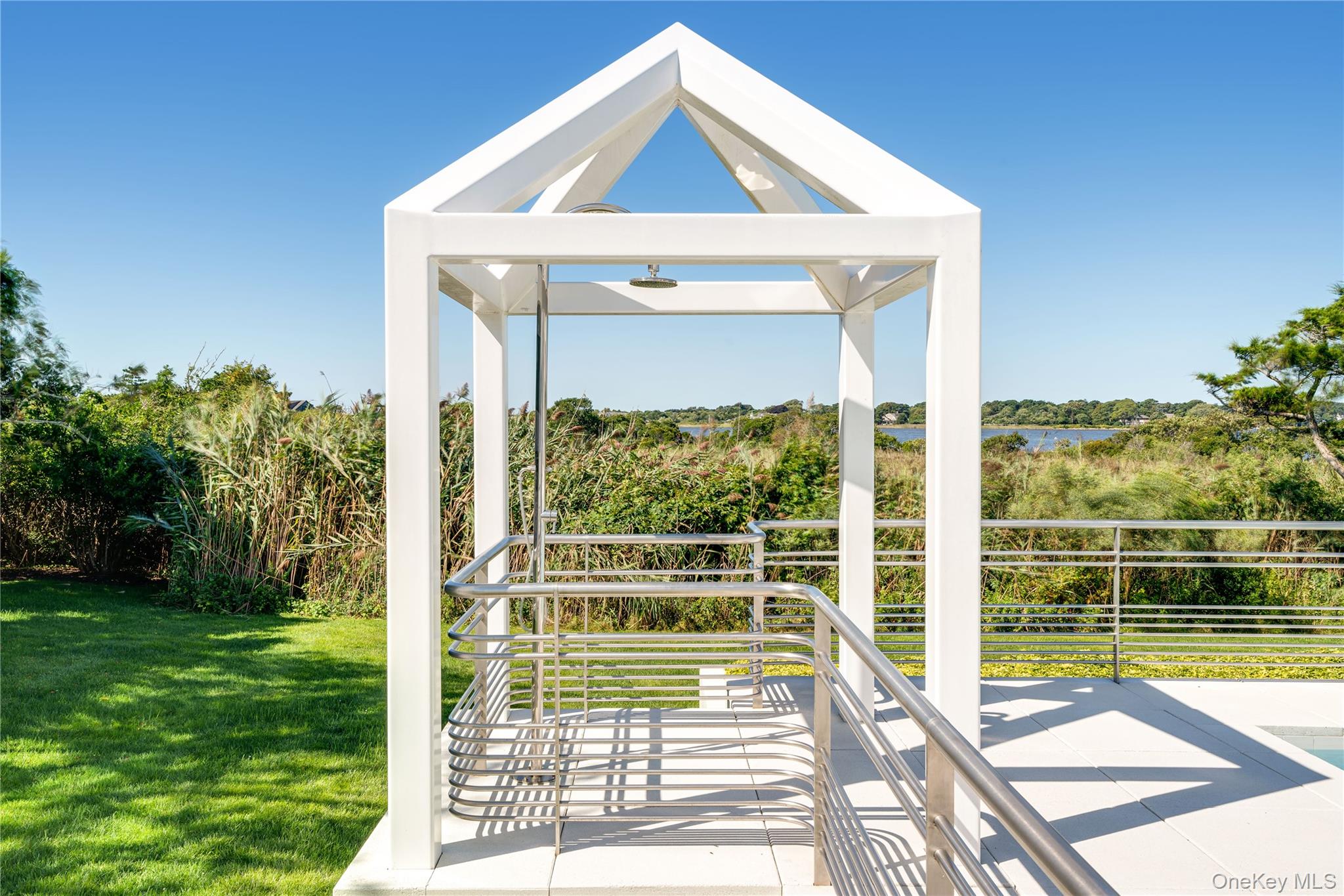 64 West End Road East Hampton, NY 11937 - Photo 25 of 33 a view of a house with a large window and a yard with plants