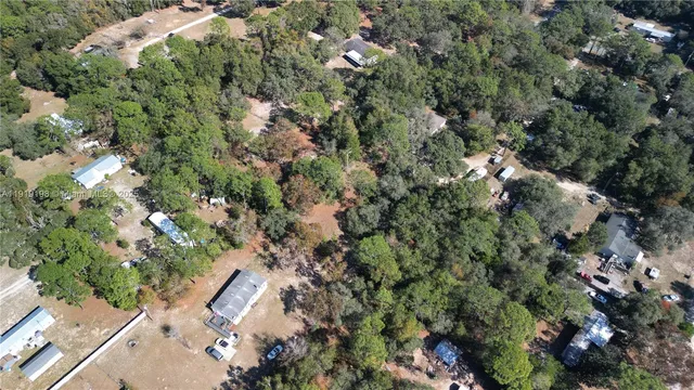 an aerial view of a house with a lush green forest