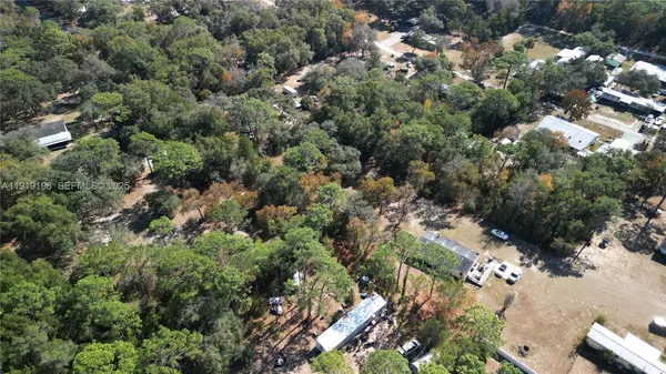 an aerial view of residential houses with outdoor space and trees
