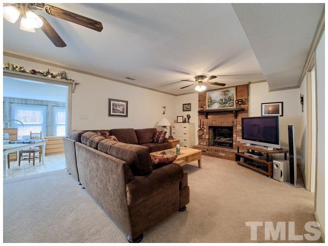 908 Orange Factory Road Bahama, NC 27503 - Photo 11 of 23 a living room with furniture a flat screen tv and a fireplace