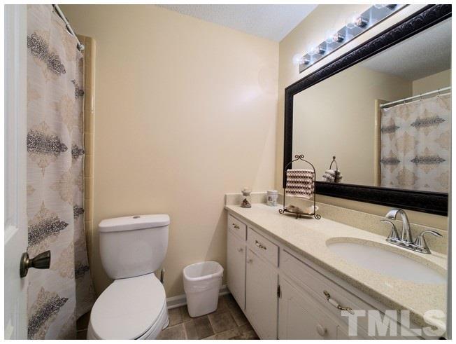908 Orange Factory Road Bahama, NC 27503 - Photo 15 of 23 a bathroom with a granite countertop toilet sink and mirror